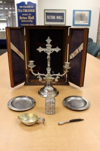 Sick call box opened to show candelabrum with crucifix, two small silver plates, holy water bottle, and silver-handled brush