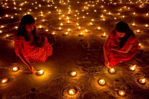 Image of people with many candles lit on the ground at night