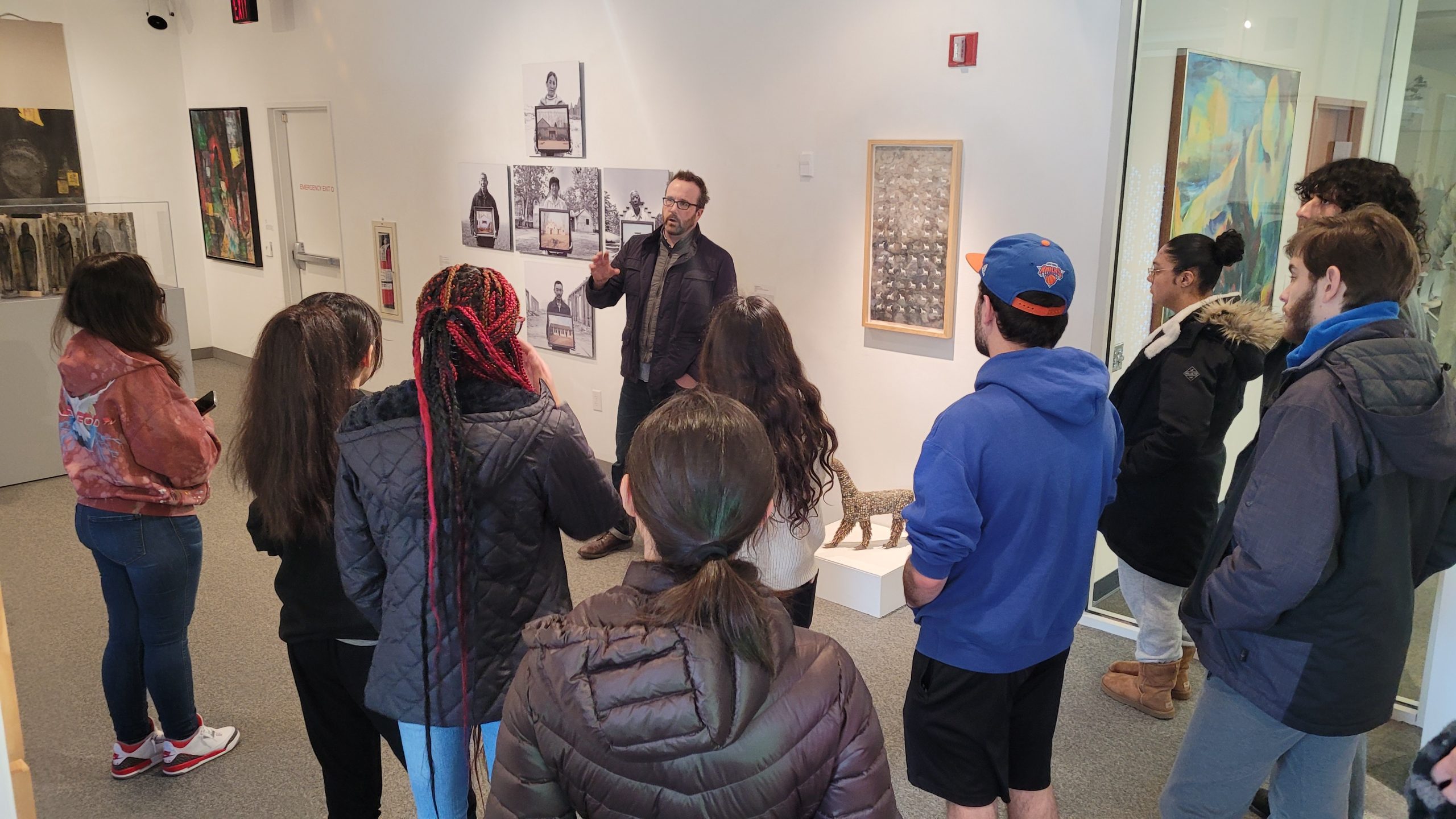 Professor Nathan Oates discusses the exhibit with students in Creative Writing I