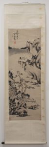 Black and white Chinese landscape painting on a scroll, with images of rocks and trees.