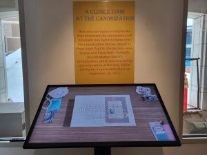 Exhibit text behind a large touch screen.