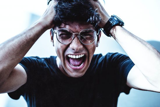 Frustrated person, grabbing his head with his mouth wide-open