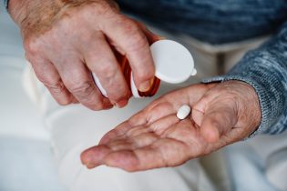 Aged hand with pill