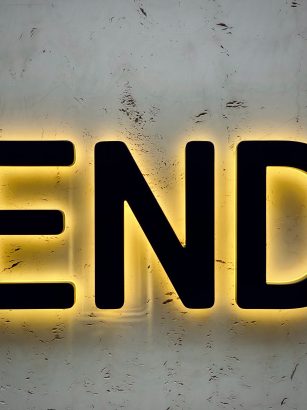 The End written on a wall with light behind the black letters