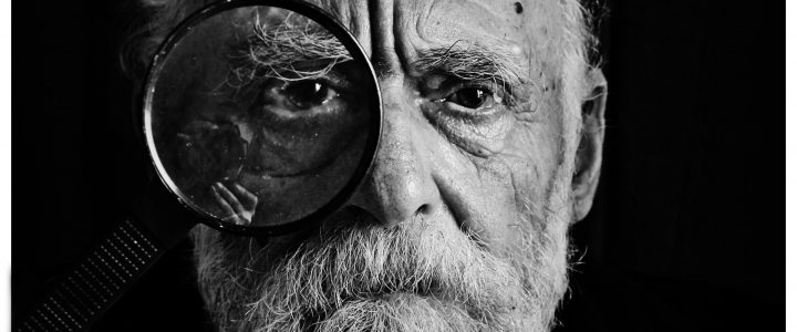 Man with magnifying glass over his left eye