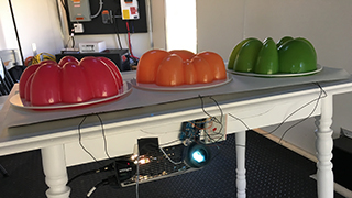 Layered Chiffon project - three 3D printed jello molds on a table with Arduino connected to run simulation when jello molds are pressed.