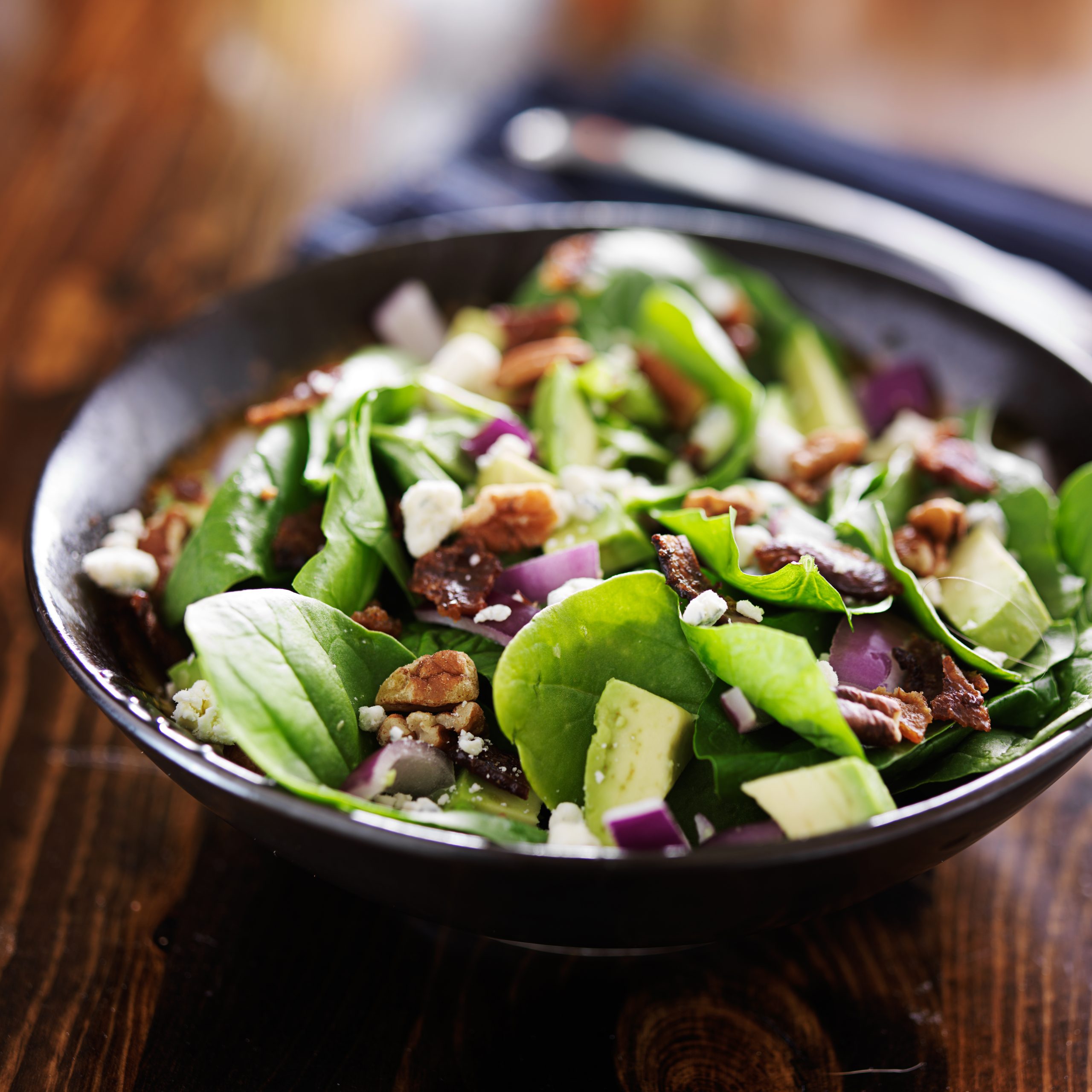 avocado spinach salad with feta cheese, pecans and bacon