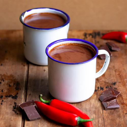 two cups of hot chocolate with a chili pepper