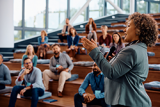 Woman of color engaged in public speaking at a business conference at convention center