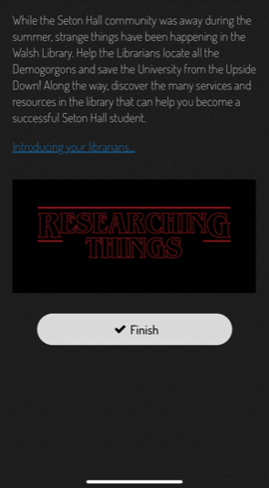 Screenshot of the library scavenger hunt app. There is a video embedded in the screen with the title "Researching Things." Text says, "While the Seton Hall community was away during the summer, strange things have been happening in the Walsh Library. Help the Librarians locate all the Demorgons and save the University from the Upside Down! Along the way, discover the many services and resources in the library that can help you become a successful Seton Hall student. Introducing your librarians..."