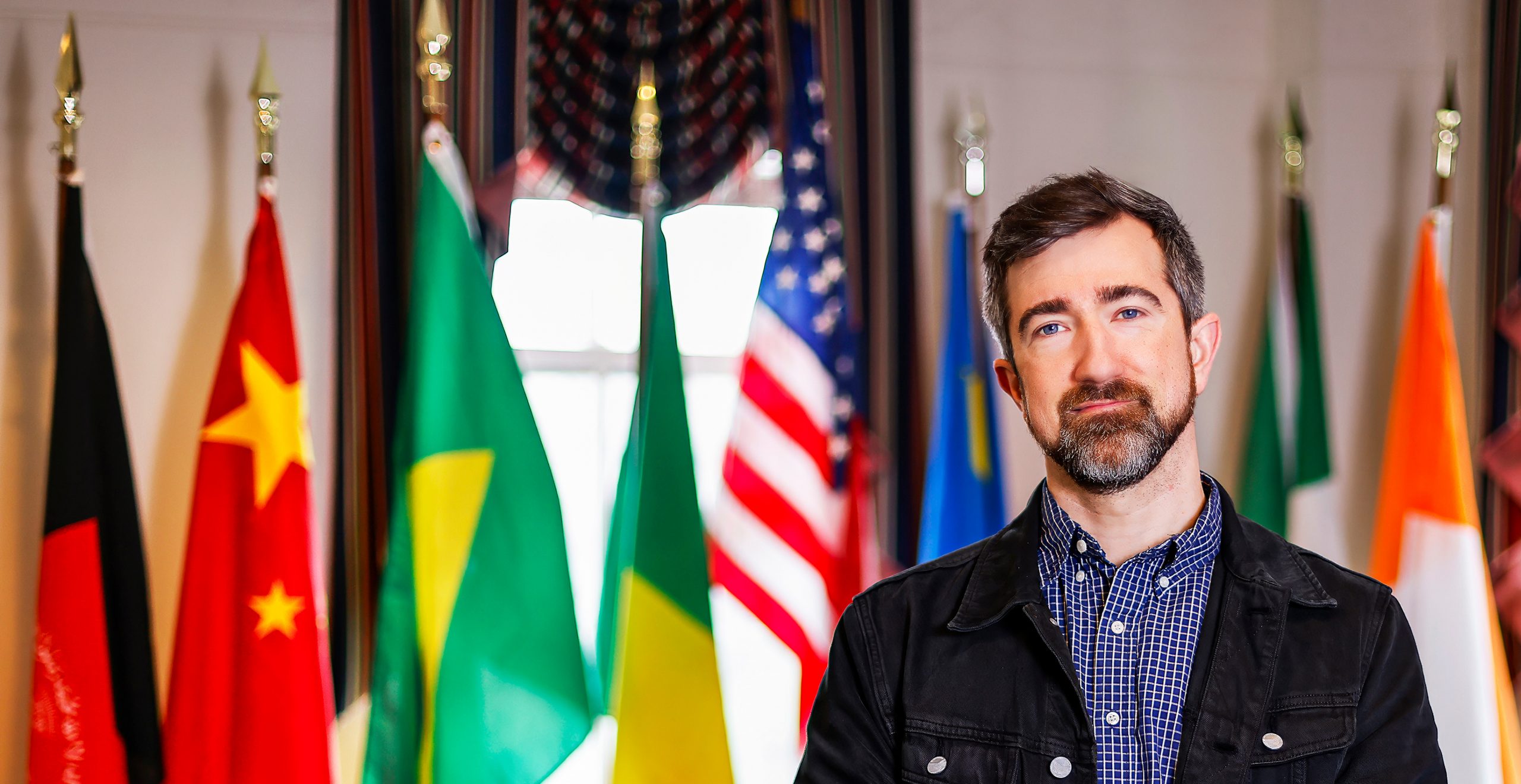 joseph huddleston standing in front of flags