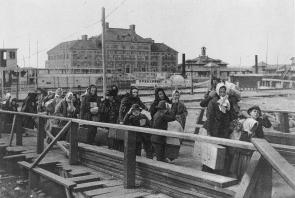 People from other countries brought two or three suitcases with their possessions to come into America. We can see the immigrants walking towards their new futures but first they had to be processed at Ellis Island Circa 1902